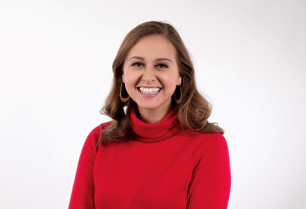 A woman in red shirt smiling for the camera.