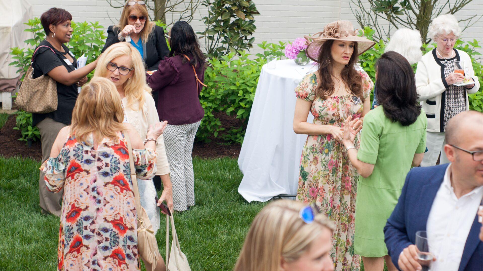 A group of women standing around in front of an outdoor table.