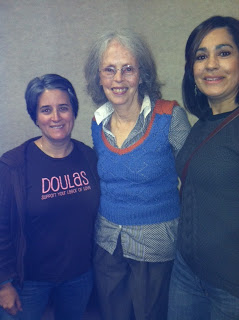 Three women standing next to each other in a room.