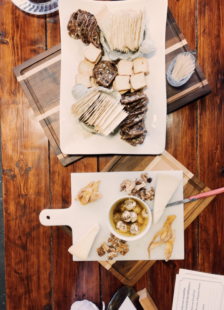 A wooden table with two trays of food on it.